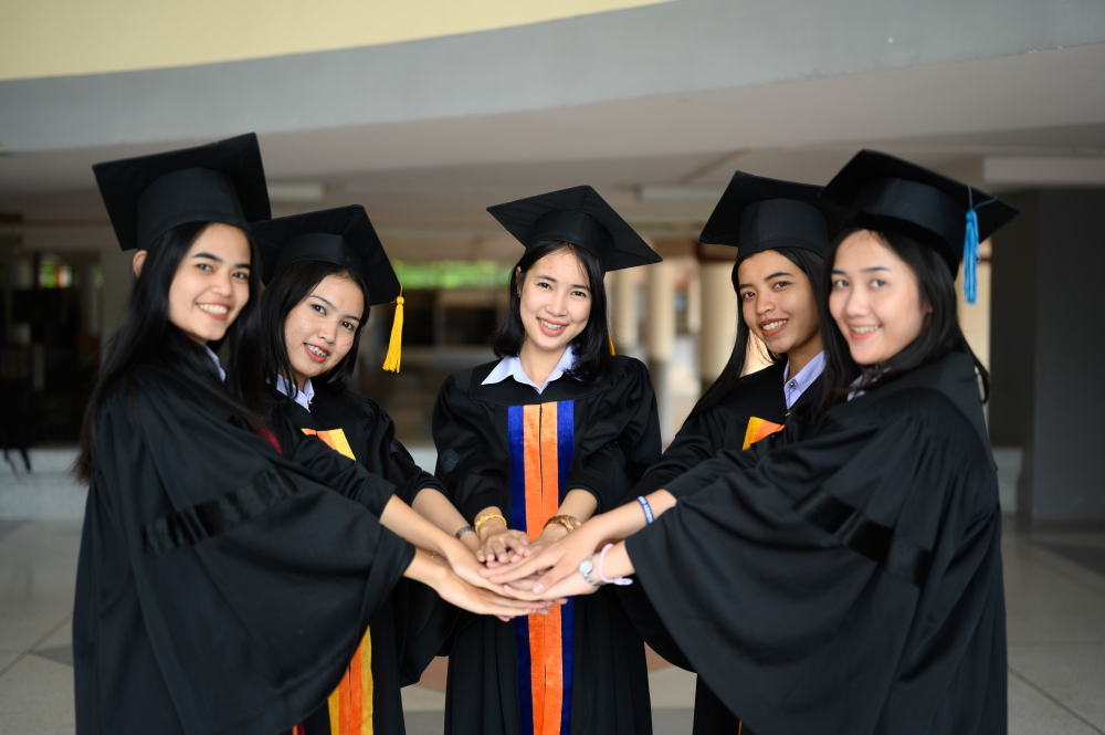 Mahasiswa mengenakan jubah wisuda berpose bersama dalam perayaan kelulusan.